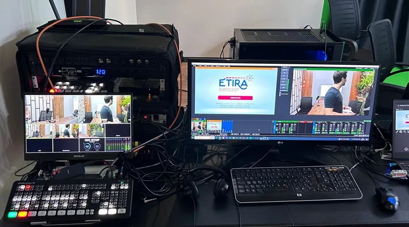 Mesa de transmissão ao vivo com switcher de vídeo e múltiplos monitores